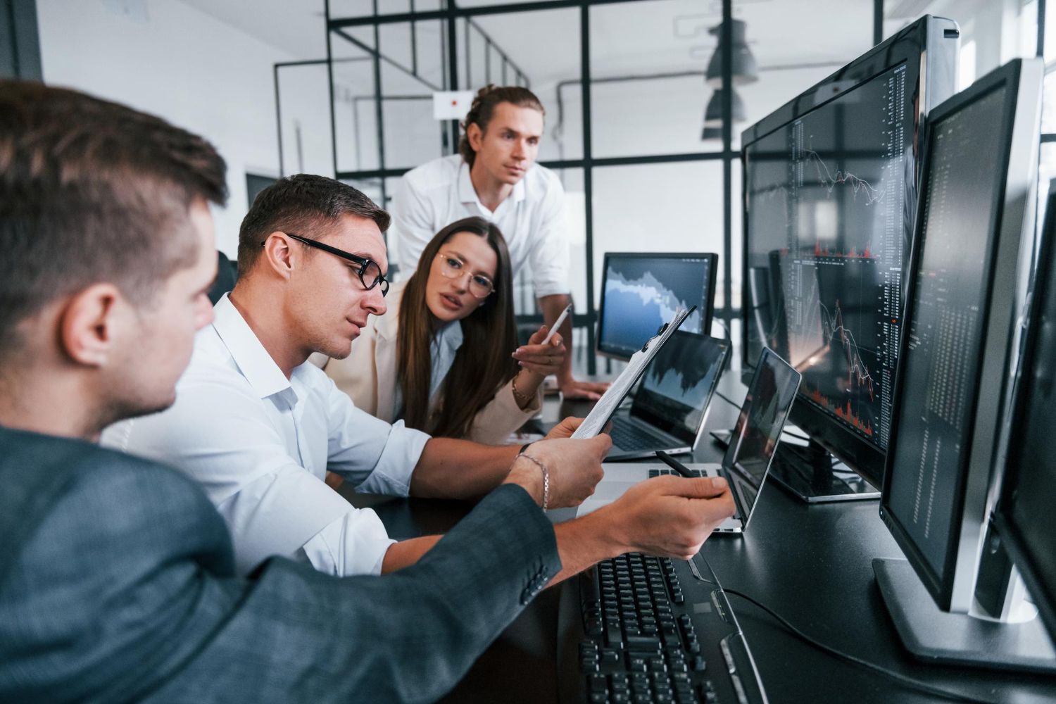 pessoas sentadas em frente as mesas com computadores.