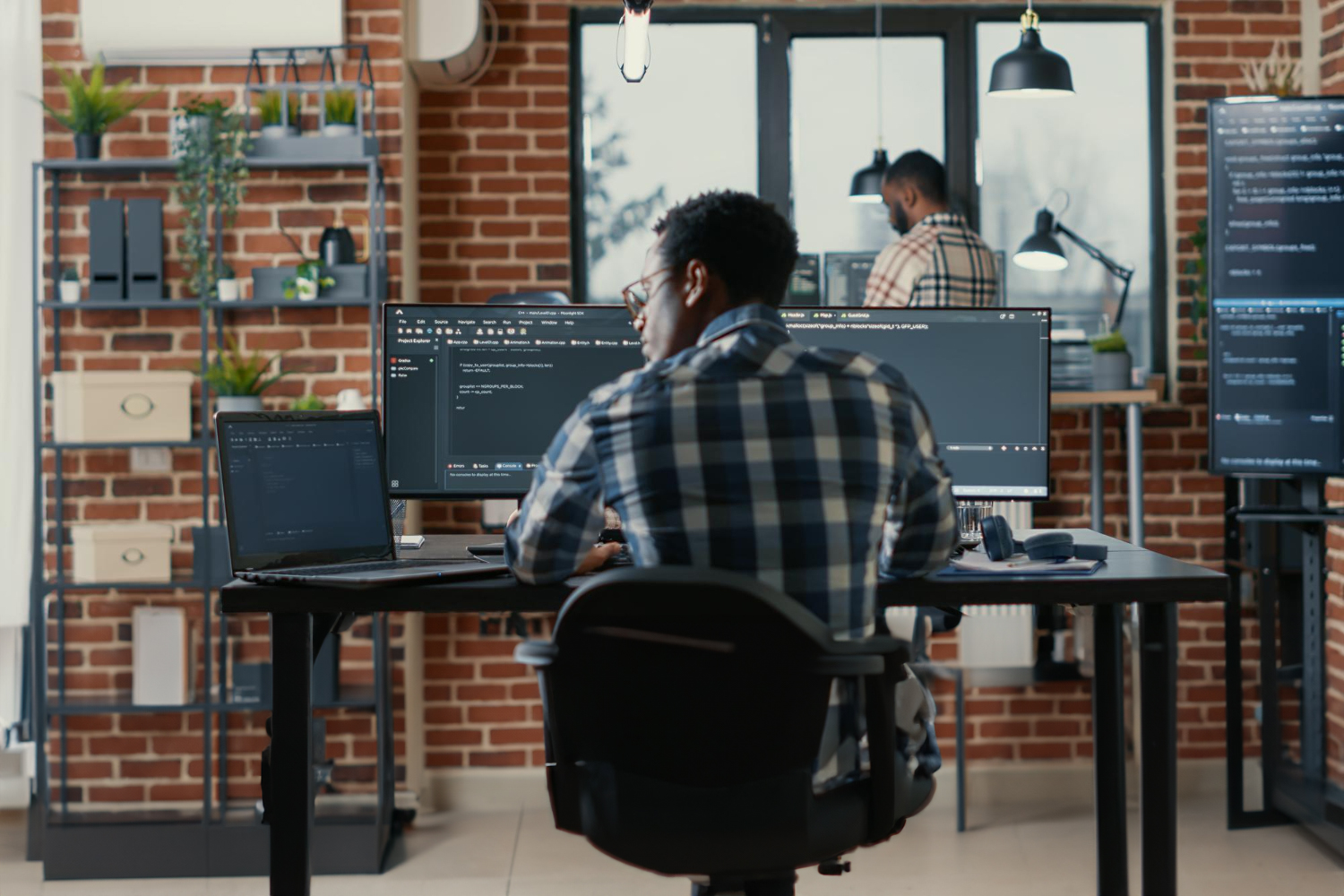 homem sentado trabalho com computadores.